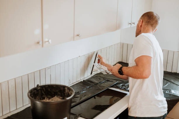 man putting up tile in kitchen<br />
Photos taken in natural light Backsplash Installation<br />